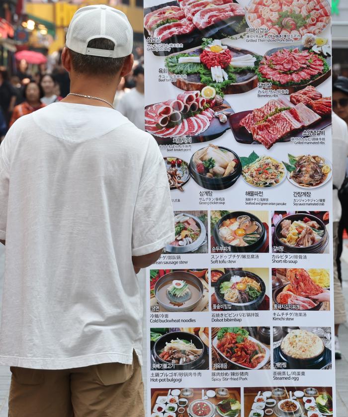 서울 시내 음식점 앞에서 한 시민이 메뉴판을 바라보고 있다. 연합뉴스