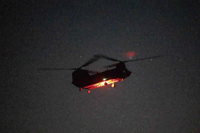 CH-47 시누크 헬기가 어둠 속에 착륙하고 있다.