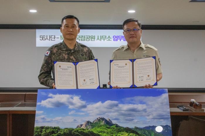 지난달 24일 박진희(왼쪽) 56보병사단장과 이천규 북한산국립공원사무소장이 업무협약을 맺은 뒤 기념사진을 찍고있다. 부대 제공