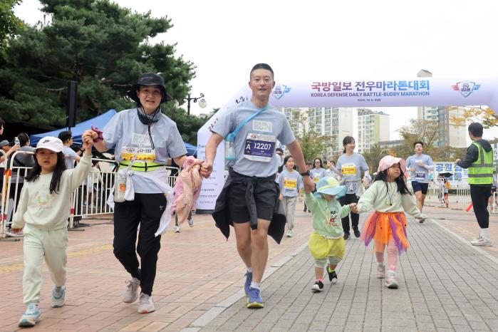 가족사랑 새록새록 참가자 부부가 아이들의 손을 잡고 함께 마라톤을 즐기고 있다.