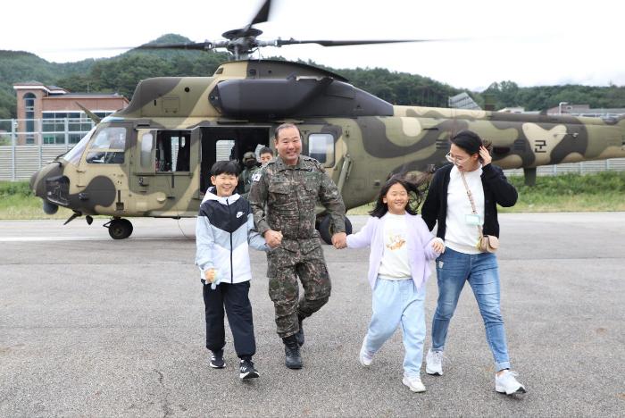 육군3군단 부대개방행사에서 수리온 헬기 탑승 체험을 마친 군인가족이 웃으며 이동하고 있다. 부대 제공