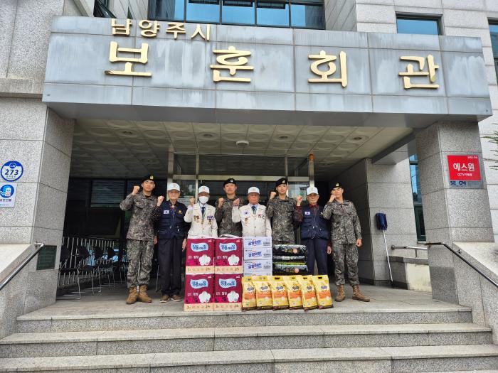 정성훈(왼쪽 넷째) 육군73보병사단 광개토여단 중대장과 장병들이 6·25참전유공자회 경기도지부 남양주시지회에 생필품을 전달한 후 참전용사들과 함께 파이팅을 외치고 있다. 부대 제공