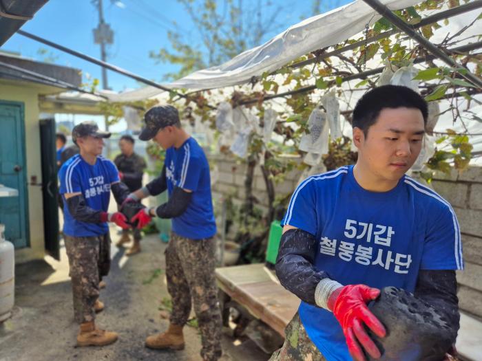 육군5기갑여단 철풍봉사단 소속 장병들이 지역 소외계층의 자택에서 연탄을 옮기고 있다. 부대 제공