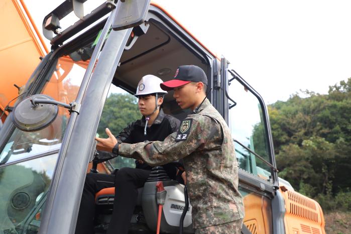 육군공병학교 공병장비 현장실습교육 중 한 특성화고 교육생이 공병학교 조교의 지도를 받으면서 굴착기 조종을 하고 있다. 사진 제공=이재섭 소령