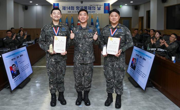 올해 최우수 방공무기통제사로 선정된 김동학(왼쪽)·조영준(오른쪽) 준위가 31일 합참의장상과 상패를 받은 후 박창규 방공관제사령관과 기념사진을 찍고 있다. 공군 제공