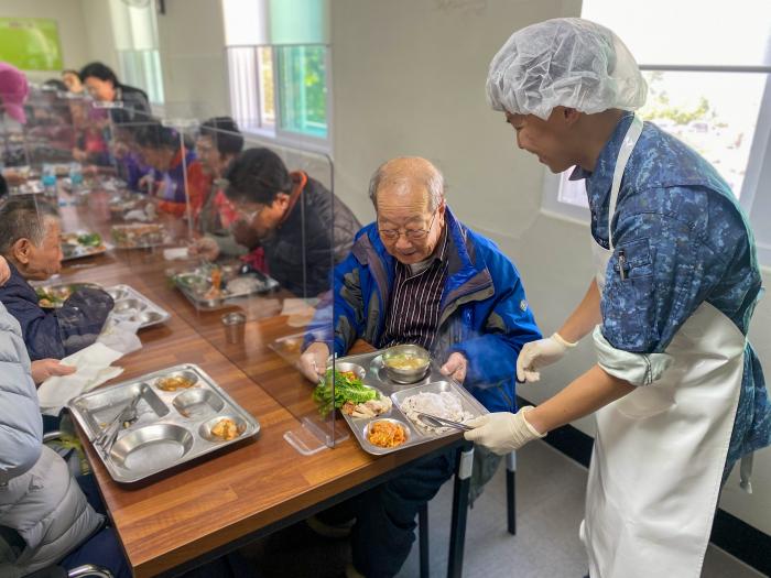 해군5전단 해남함 승조원이 6일 전남 해남군 장애인종합복지관에서 어르신의 식사를 돕고 있다. 부대 제공