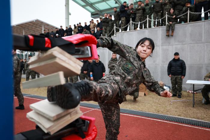 격파 부문에서 한 육군 장병이 옆차기로 나무 송판을 격파하고 있다. 