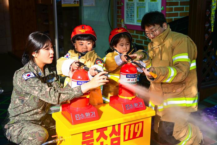 공군3훈련비행단 소방구조중대 장병들이 기지 내 어린이집 원생의 소화기 사용 체험을 돕고 있다. 부대 제공