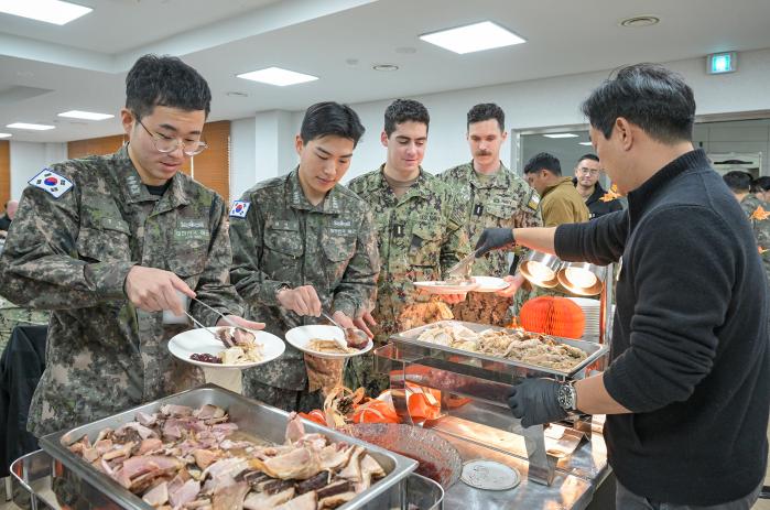 한미 해군 장병들이 27일 부산 해군전투력복원센터에서 양국 대표 명절 음식인 칠면조 요리와 약과를 접시에 담고 있다. 부대 제공