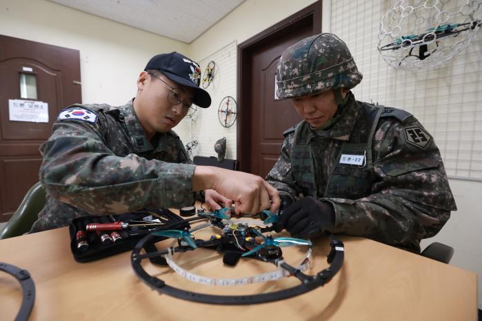 드론을 정비하는 교관과 교육생.