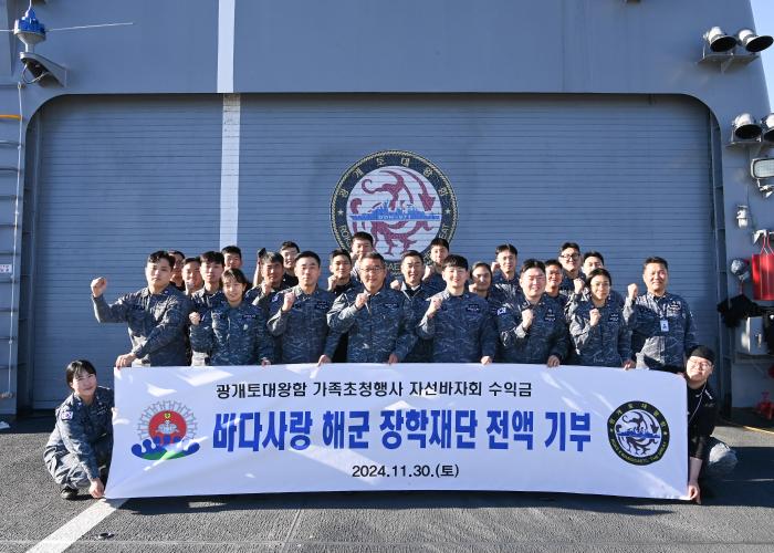 해군1함대 광개토대왕함 승조원들이 바다사랑 해군 장학재단에 바자회 수익금 기부를 기념하며 포즈를 취하고 있다. 부대 제공