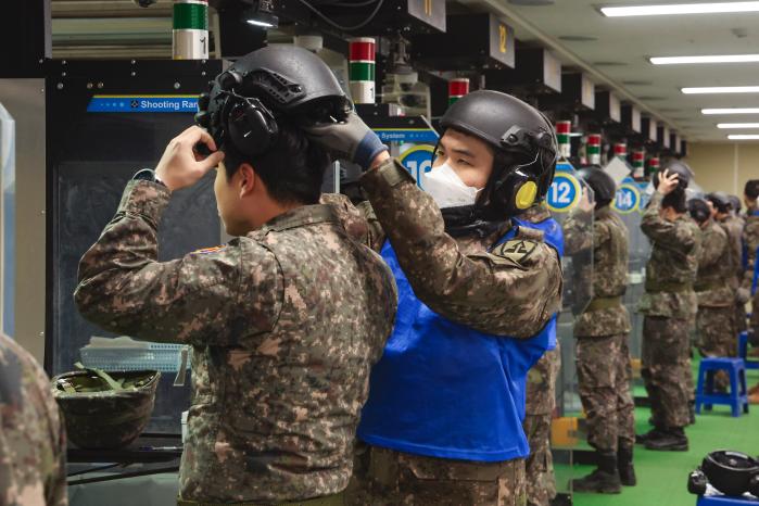 개인화기 조교가 사격 전 예비군의 청력보호헬멧 착용을 돕고 있다.