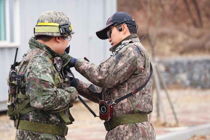 시가지전투훈련 교관이 훈련 후 예비군 팔에 부착된 마일즈 장비를 확인하고 있다.