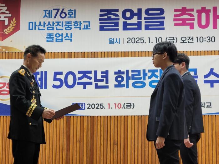 이윤규(왼쪽) 한국군사문제연구원 연구본부장이 지난 10일 열린 마산삼진중학교 졸업식에서 장학금을 수여하고 있다. 한국군사문제연구원 제공