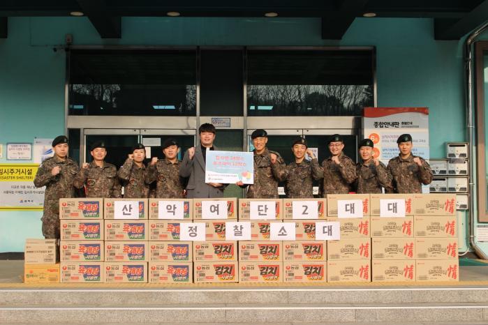 육군1산악여단 2대대 정찰소대 장병들이 탑팀 선발대회 수상 상금으로 마련한 물품을 기부하며 기념사진을 찍고 있다. 부대 제공