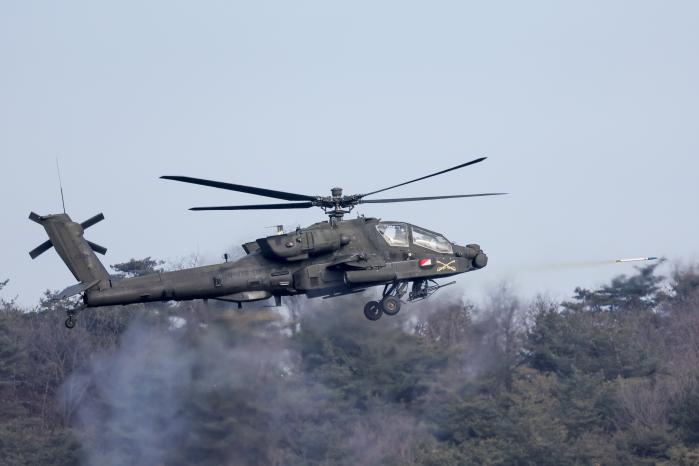 미 AH-64E 아파치 공격헬기가 2.75인치 로켓을 쏘는 모습.