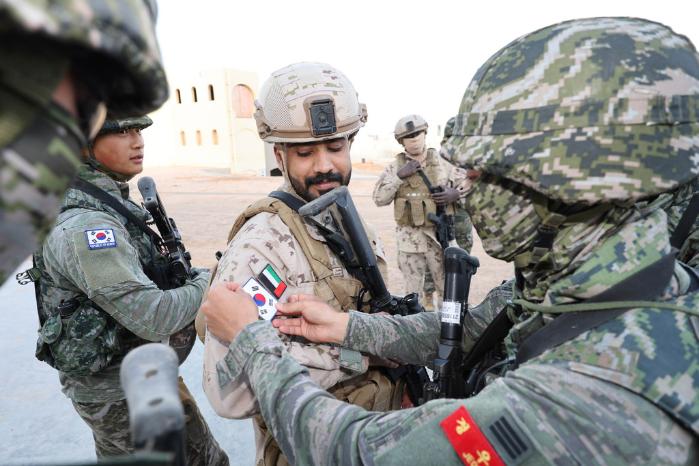해병대2사단 장병이 훈련 후 UAE군 장병 전투복에 태극기를 붙여 주고 있다.