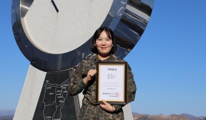 육군21보병사단 권솔 하사가 머리카락 기부 후 어머나운동본부로부터 받은 기부증서를 들고 있다. 부대 제공