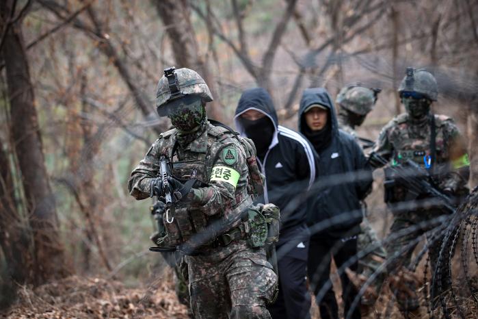 5분전투대기부대 장병들이 방공진지 침투를 시도한 거동수상자를 포획해 이송하고 있다.