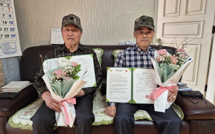 전역 후 55년 만에 병장특별진급을 한 윤동인(왼쪽)·이용학 옹이 기념촬영을 하고 있다. 부대 제공