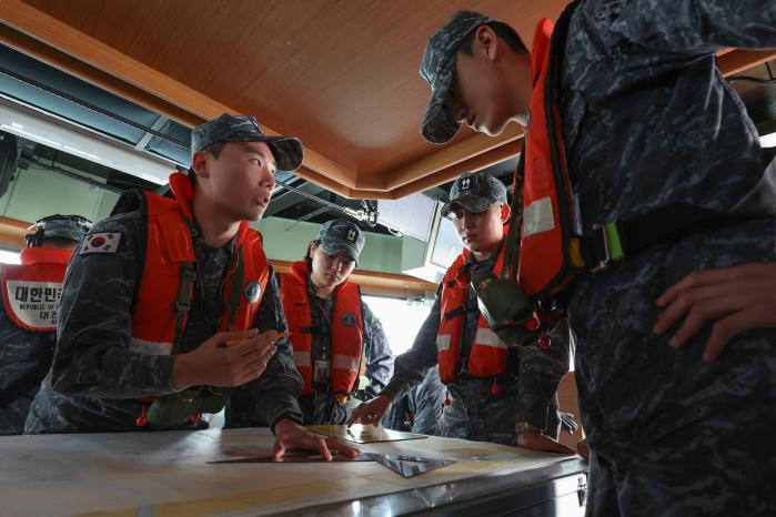 해도를 보며 함정 위치를 산출하고 있는 승조원들.