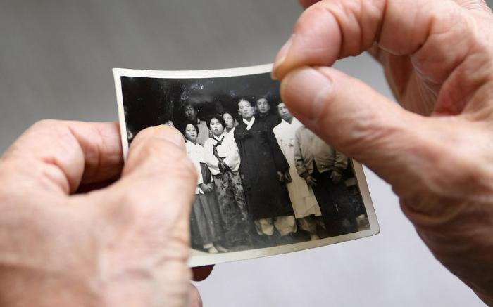 지난 13일 경남 창원시 마산합포구의 한 아파트에서 1958년 육군에 입대해 복무하다가 결핵성 뇌막염으로 사망한 고 김종원 이병의 남동생이 국방부조사본부 전사망민원조사단 조사관들과 이야기를 나누며 과거 흑백사진을 살펴보고 있다.