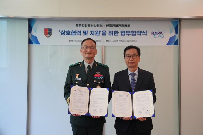 조재명(왼쪽) 국군지휘통신사령관과 정흥보 한국전파진흥협회 상근부회장이 23일 업무협약서를 들어 보이고 있다. 부대 제공