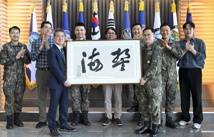 하성욱(앞줄 오른쪽) 해군항공사령관이 29일 남성운(앞줄 왼쪽) 국립항공박물관 학예연구본부장에게 이승만 전 대통령의 친필 휘호 영인본 ‘서해(誓海)’를 전달하고 있다. 사진 제공=고명규 하사