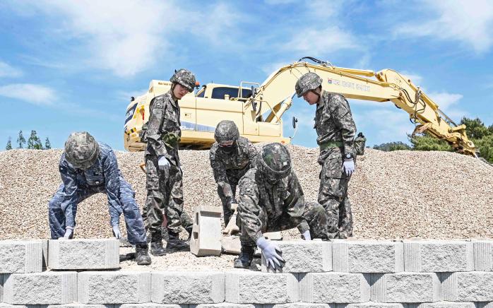29일 해군3함대 항만피해복구 훈련에서 공병대대 장병들이 적 미사일 공격 상황을 가정해 피폭된 군항 부두를 복구하며 보강토 블록을 쌓고 있다. 부대 제공