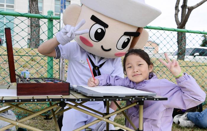 해군1함대 어린이날 부대 개방행사에서 어린이가 해군 마스코트 인형을 쓴 장병과 기념촬영을 하고 있다. 부대 제공