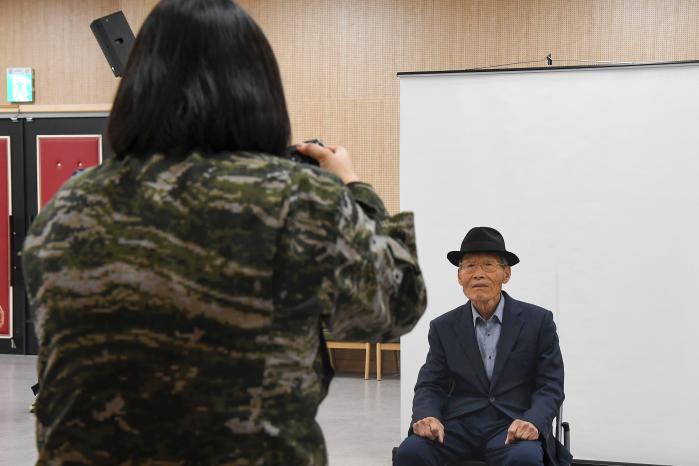 해병대1사단 정훈실 장병이 8일 경북 포항시 장기면 복지회관을 찾아 어르신의 장수사진을 촬영하고 있다. 부대 제공