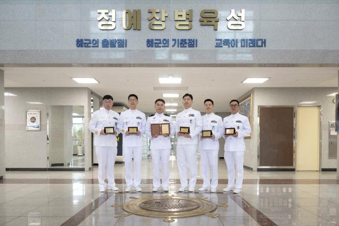 특기를 살려 13년 동안 봉사활동을 이어 온 해군교육사령부 기술행정학교 전기학과 교관 6명이 창원시장 표창을 들고 기념 촬영을 하고 있다. 사진 제공=홍성민 하사
