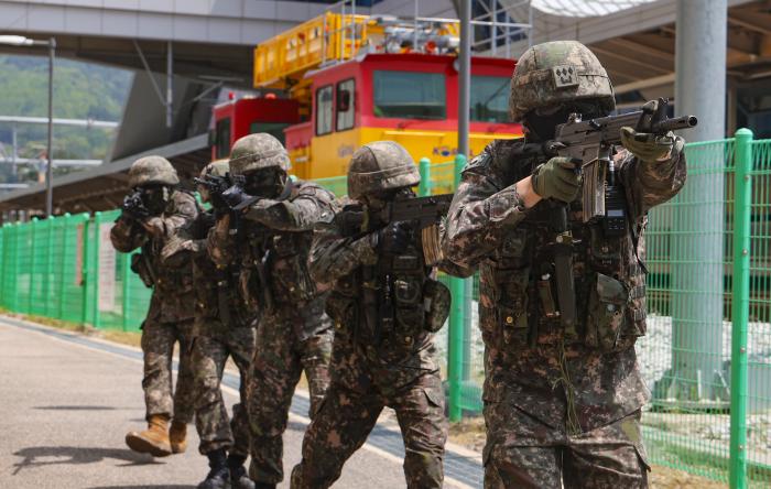 육군36보병사단 평창대대 장병들이 13일 KTX 평창역에서 열린 민·관·군·경·소방 통합방위훈련에서 역사 주변을 정찰하고 있다. 