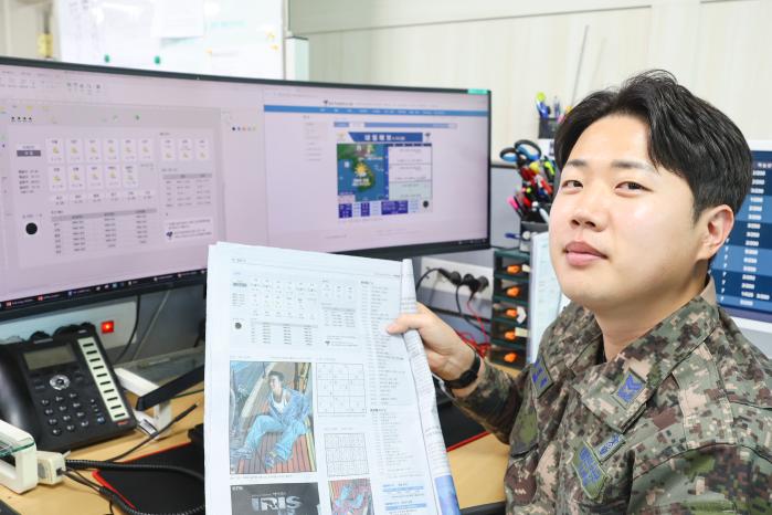 국방일보에 날씨 정보를 제공하는 정인창 예보관이 국방일보를 들어 보이고 있다.