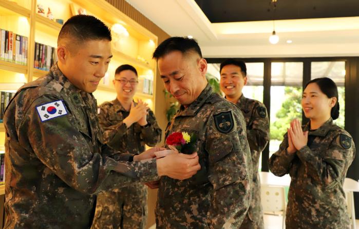 육군화생방학교 교관 박종근(맨 왼쪽) 소령이 스승인 현동준(대령) 교무처장 가슴에 카네이션을 달아주는 동안 김성용·전영민·이효진(뒷줄 왼쪽부터) 소령이 박수를 치고 있다.