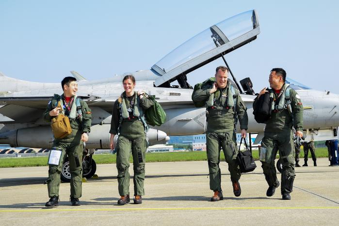 공군 시험평가단을 방문한 미 해군 시험비행학교 조종사들과 한국 시험비행 조종사들이 비행을 마친 뒤 활짝 웃으며 대화를 나누고 있다. 공군 제공