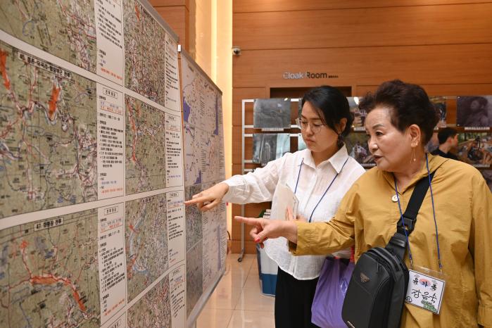 22일 대구에서 열린 ‘6·25 전사자 유해발굴사업 설명회’에 참석한 유가족들이 행사장 내 벽면에 설치된 6·25전쟁 주요 전사 자료를 보고 있다. 국유단 제공