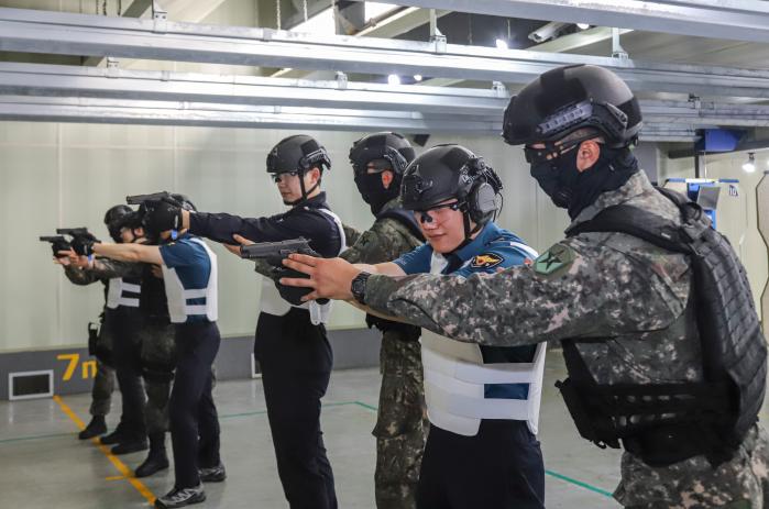 육군종합행정학교 군사경찰교육단 조교들이 합동훈련에서 경찰인재개발원 경호교육 요원들에게 사격술을 지도하고 있다. 부대 제공