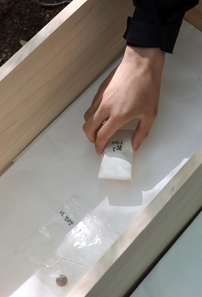 한지에 싼 유해를 입관하는 모습.