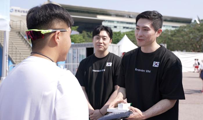 국군 영웅 감사 챌린지에서 이찬호(맨 오른쪽)·이한 예비역 병장이 한 시민에게 ‘REMEMBER 804’ 티셔츠를 전달하고 있다. 국군예우사업회 제공.