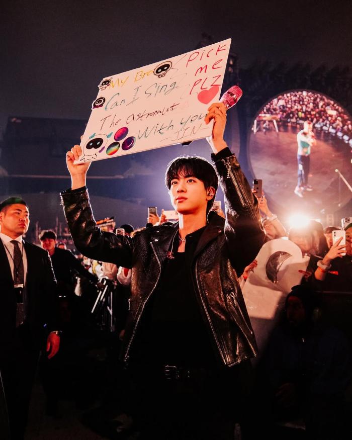 그룹 ‘BTS’ 멤버 진이 지난달 경기 고양종합운동장에서 열린 콜드플레이의 내한 공연에서 플래카드를 들고 서 있는 모습. 이날 진은 무대에 올라 합동공연을 했다.