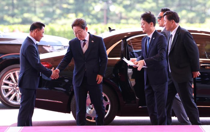 대통령실 첫 출근…이재명 대통령이 용산 대통령실 청사로 들어서며 관계자와 인사하고 있다.연합뉴스