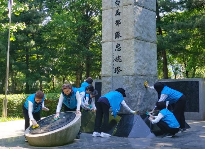 향군 중앙회 여성회와 강남구 여성회 회원들이 서울 양재동 유격백마부대 충혼탑 주변을 깨끗하게 정리하고 있다. 향군 제공