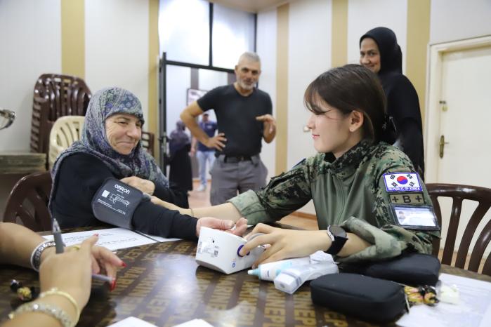 ‘찾아가는 의료서비스’를 진행하고 있는 동명부대 31진 의무대 이인우(대위·오른쪽) 간호장교가 현지인의 혈압을 재고 있다. 부대 제공