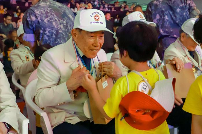 육군56보병사단 안보공감 부대개방 행사에 참석한 참전용사가 어린이로부터 선물을 받고 있다. 부대 제공