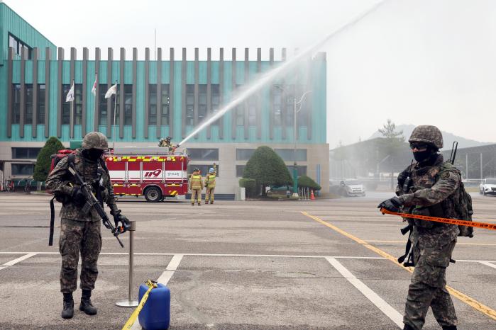 소방차가 화재 진압을 하는 동안 외곽을 경계하는 장병들.