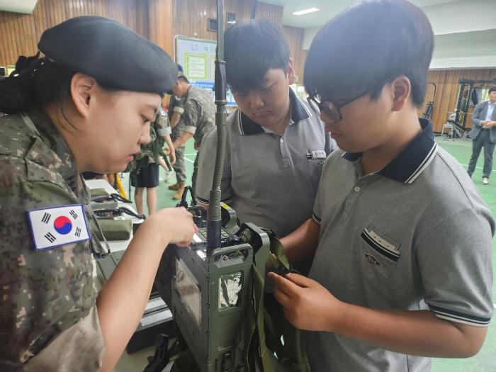 육군32보병사단이 개최한 부대 초청행사에서 한 장교가 중학생에게 군 장비를 소개하고 있다. 부대 제공