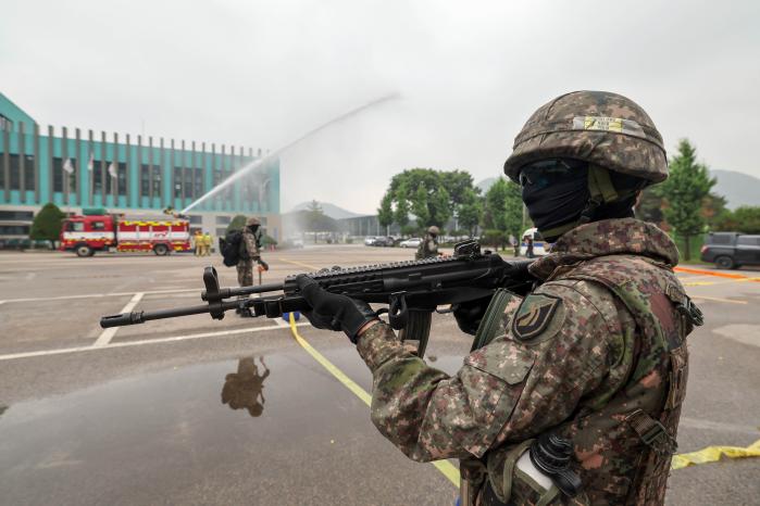 육군51보병사단 기동타격대 장병들이 16일 경기 광명시 노온정수장에서 이뤄진 국가중요시설 방호훈련 중 출동한 소방차가 화재 진압을 하는 동안 외곽을 경계하고 있다. 양동욱 기자