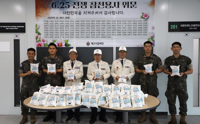 육군2기갑여단 장병들이 경기 파주시 보훈회관에서 열린 사랑의 쌀 전달식에서 선배 전우들과 기념촬영을 하고 있다. 부대 제공