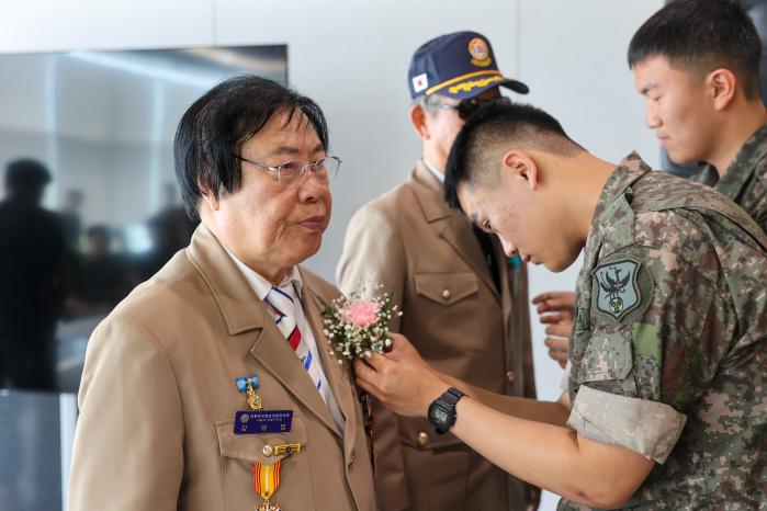 국군화생방방호사령부 장병들이 참전용사에게 감사의 마음을 담은 카네이션을 달아드리고 있다.